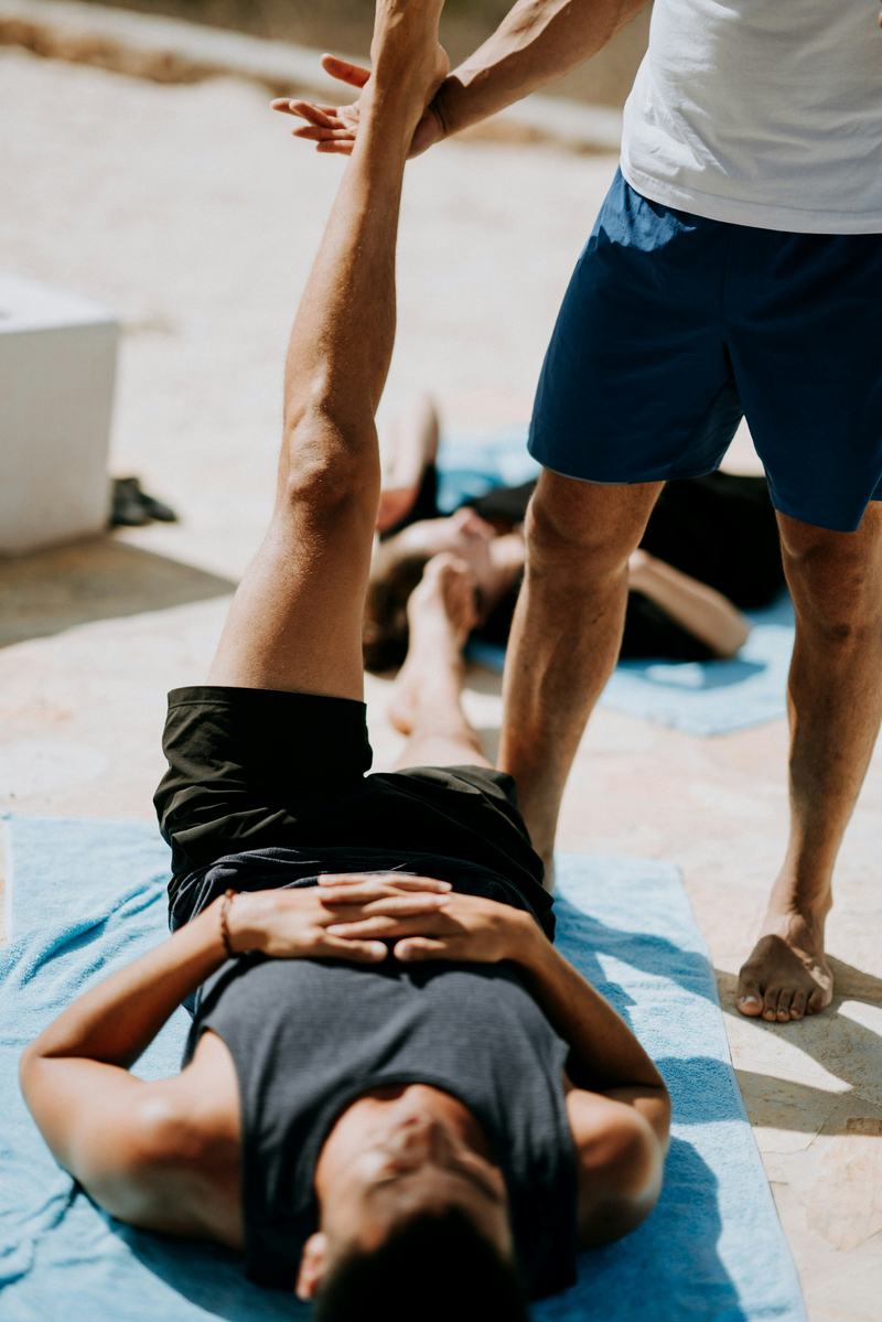Trainer guiding a client through an assisted hamstring stretch